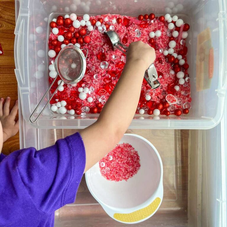 little boy scooping red and pink rice