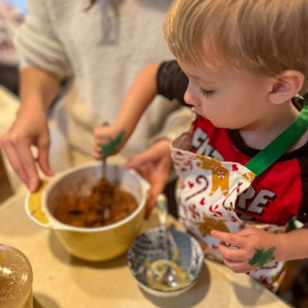 little boy mixing dough in a bowl