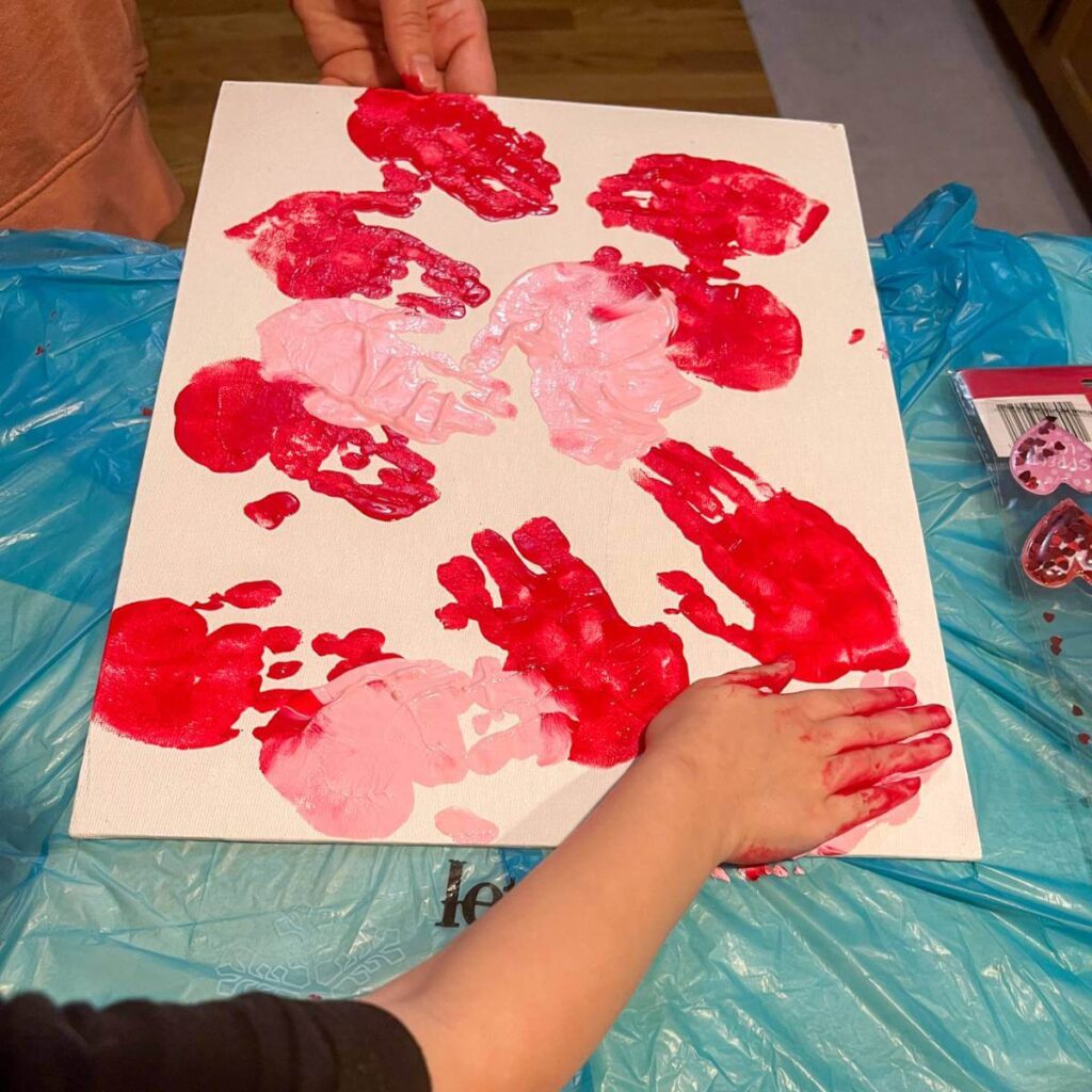 canvas with red and pink handprints