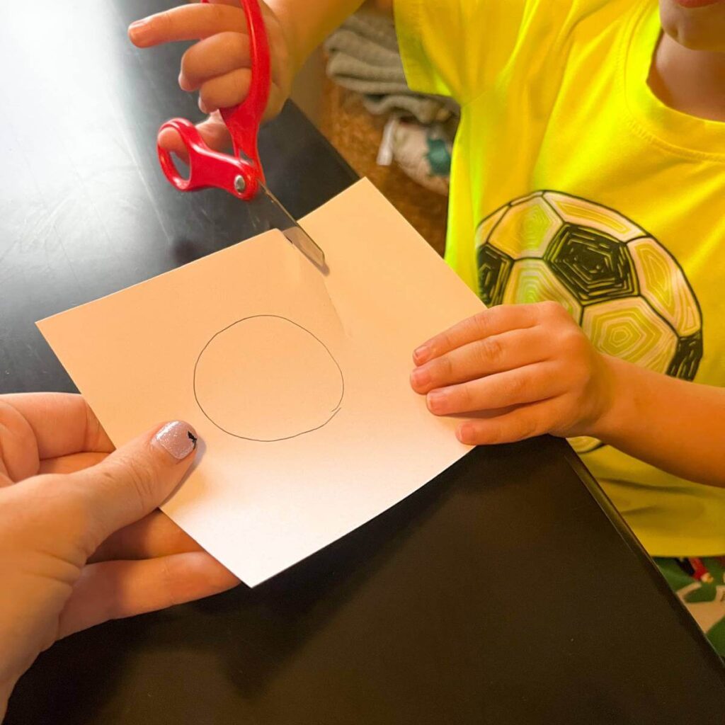 child cutting paper with scissors